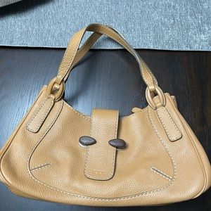 Tod’s Pebble Leather Handbag with wood detail.  It’s a beige/orange color.